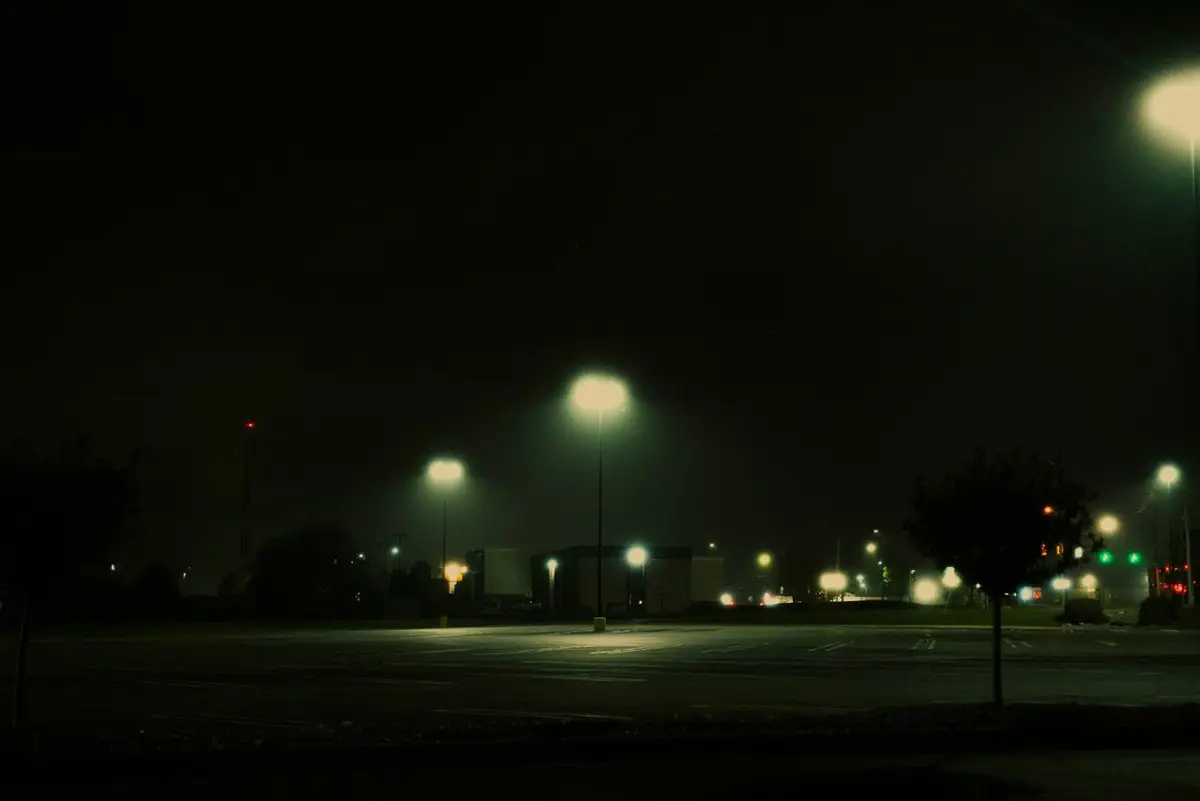 An empty car park at night under street lights