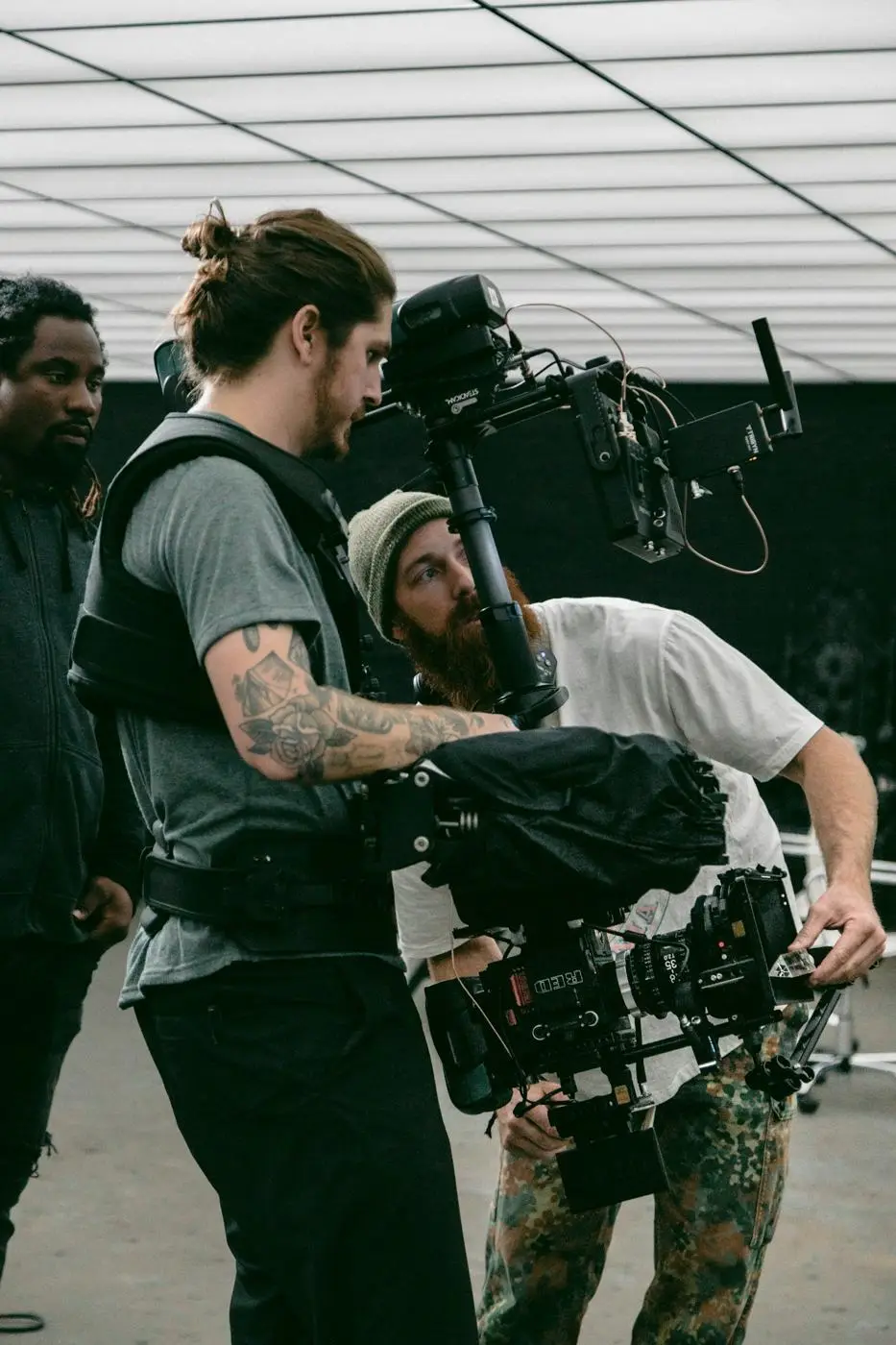 Two young crew members carrying a camera rig between setups